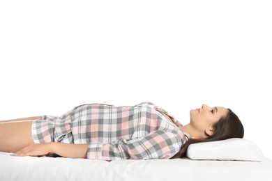 Photo of Beautiful pregnant woman lying with orthopedic pillow on bed against white background