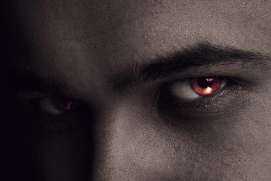 Image of Evil eye. Man with red demonic eyes, closeup