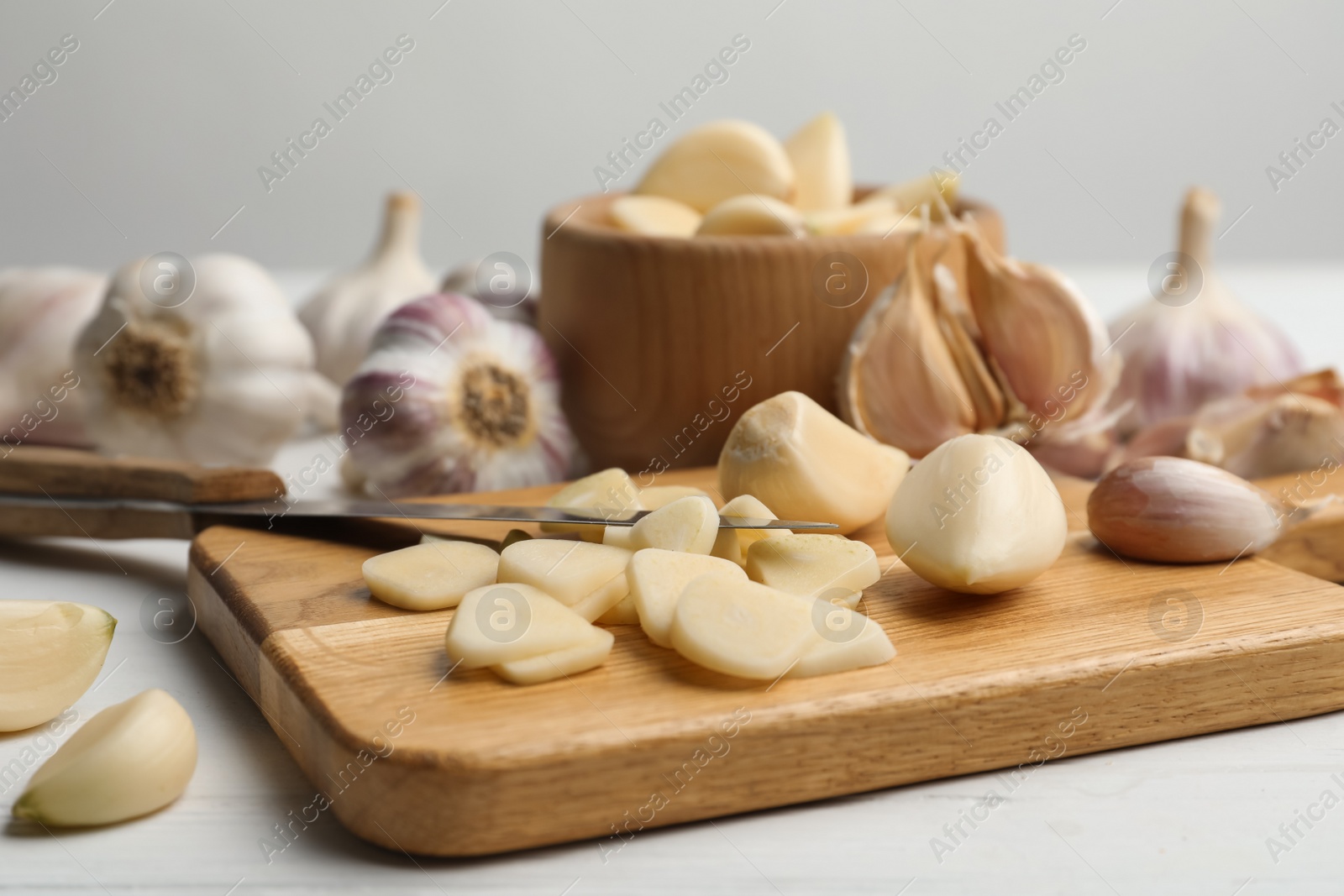 Photo of Fresh chopped garlic on wooden board, closeup. Organic product