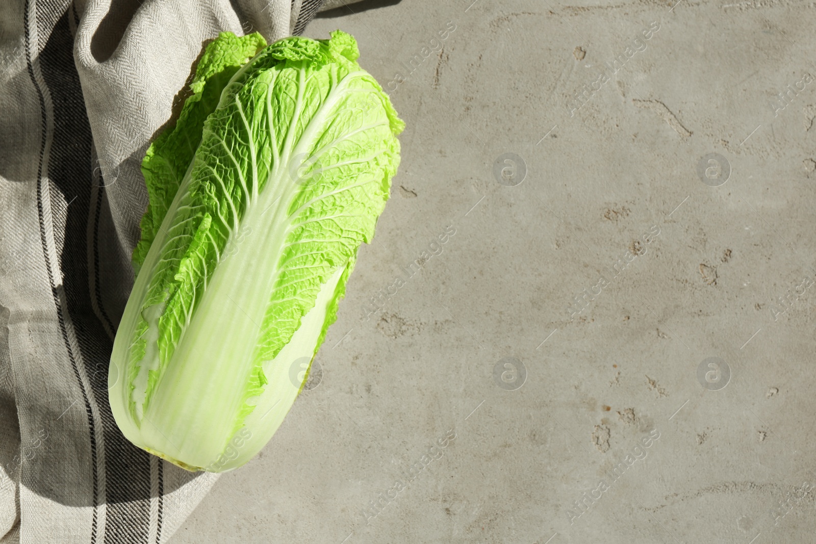 Photo of Fresh ripe Chinese cabbage on gray textured table, top view. Space for text