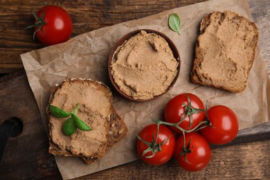 Photo of Fresh bread with delicious meat pate, cherry tomatoes and basil on wooden table, flat lay