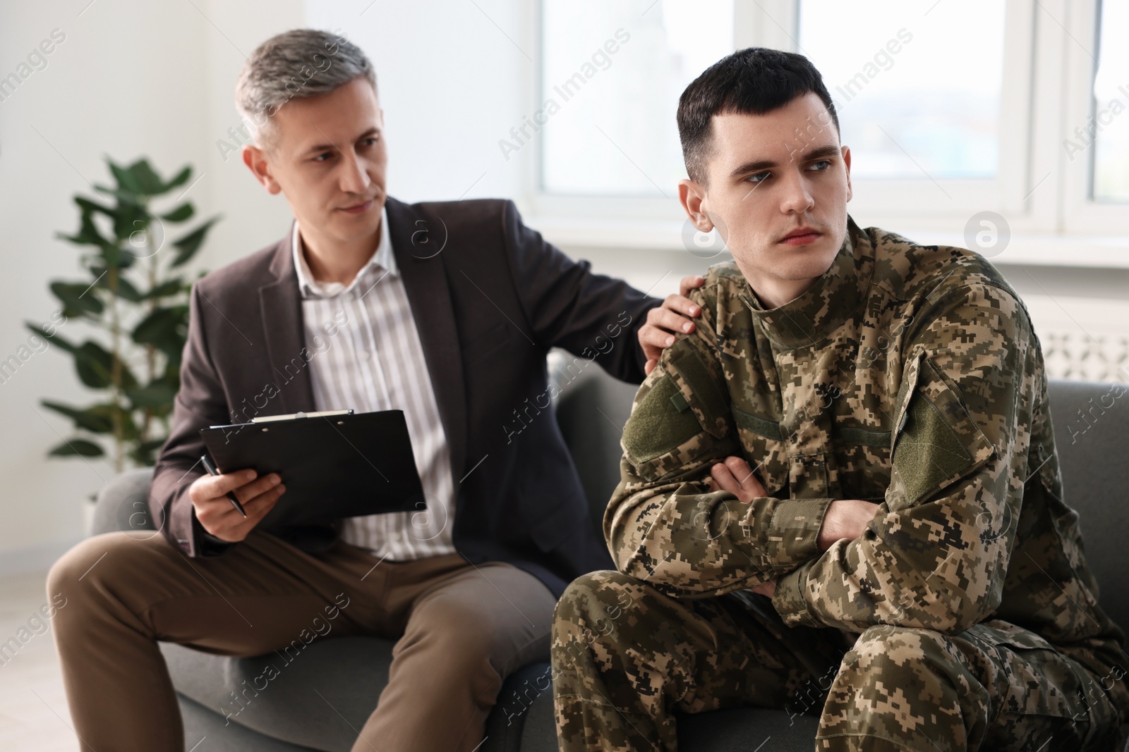 Photo of Professional psychotherapist working with military man in office