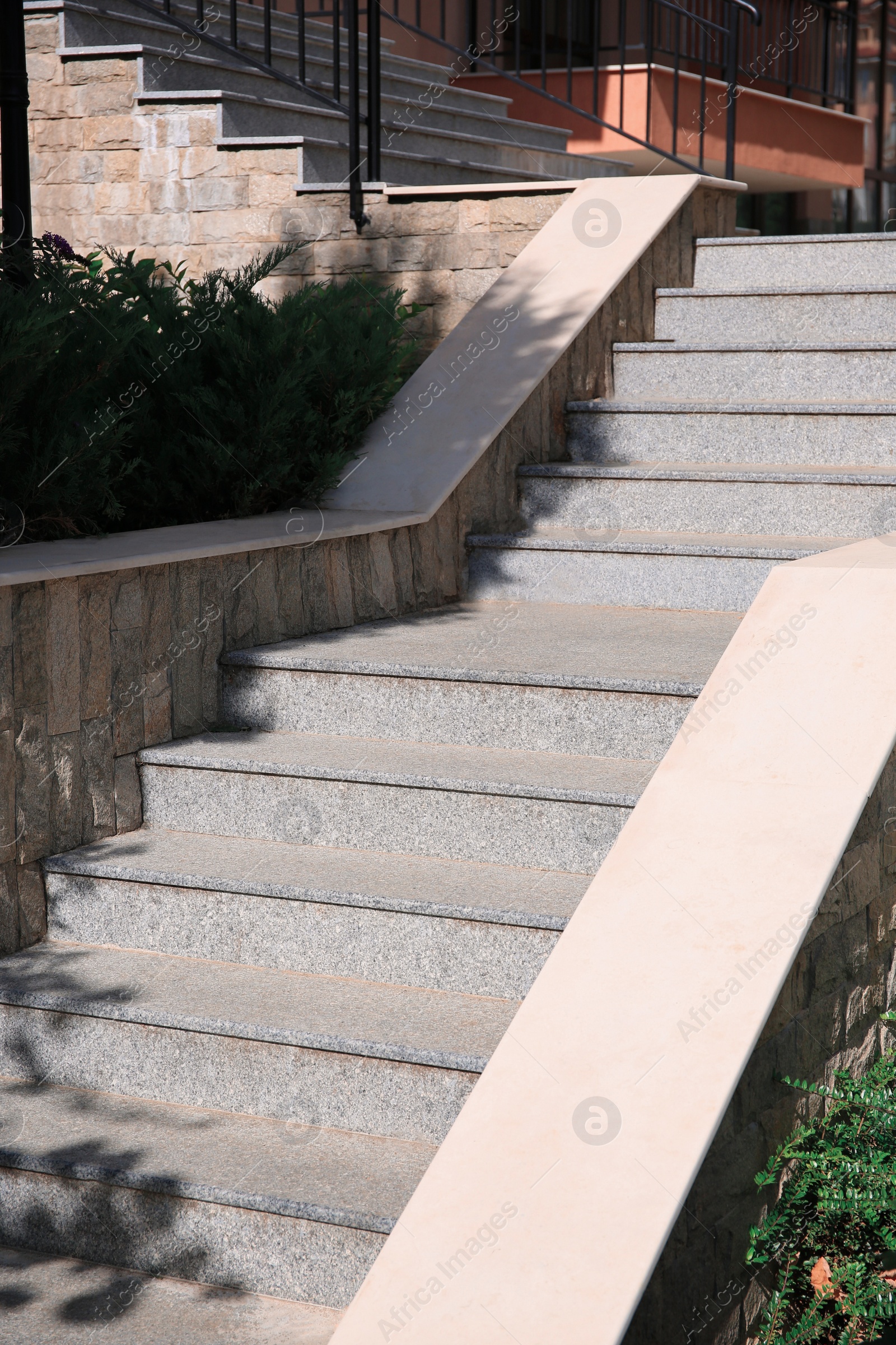 Photo of View of beautiful grey concrete stairs near plants outdoors