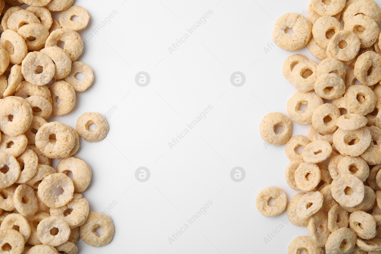 Photo of Tasty cereal rings on white background, flat lay. Space for text