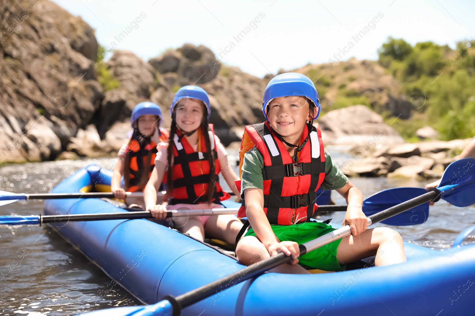 Photo of Little children kayaking on river. Summer camp