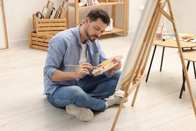 Photo of Handsome man painting in studio. Creative hobby