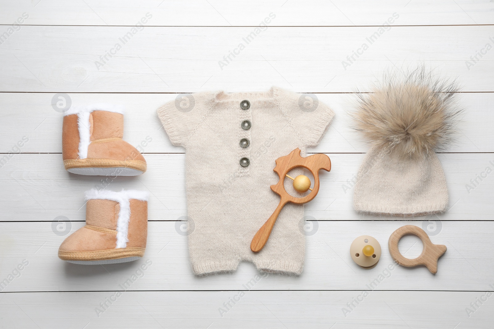 Photo of Flat lay composition with child's clothes and accessories on white wooden table