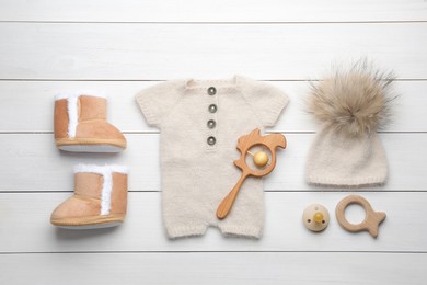 Flat lay composition with child's clothes and accessories on white wooden table