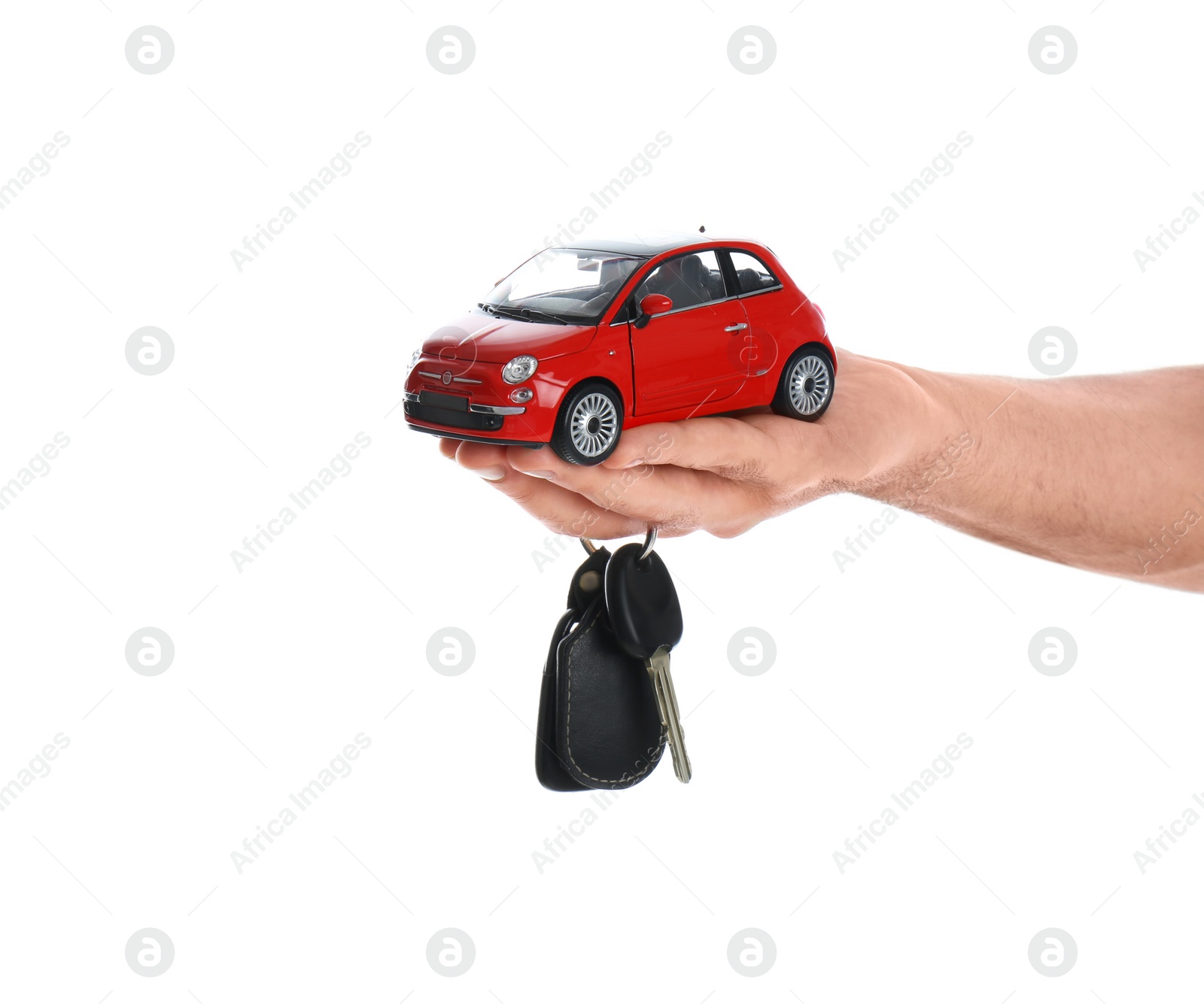 Photo of Man holding key and miniature automobile model on white background, closeup. Car buying