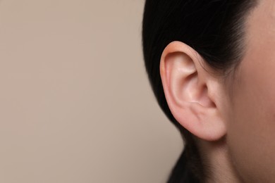 Photo of Woman on grey background, closeup of ear. Space for text