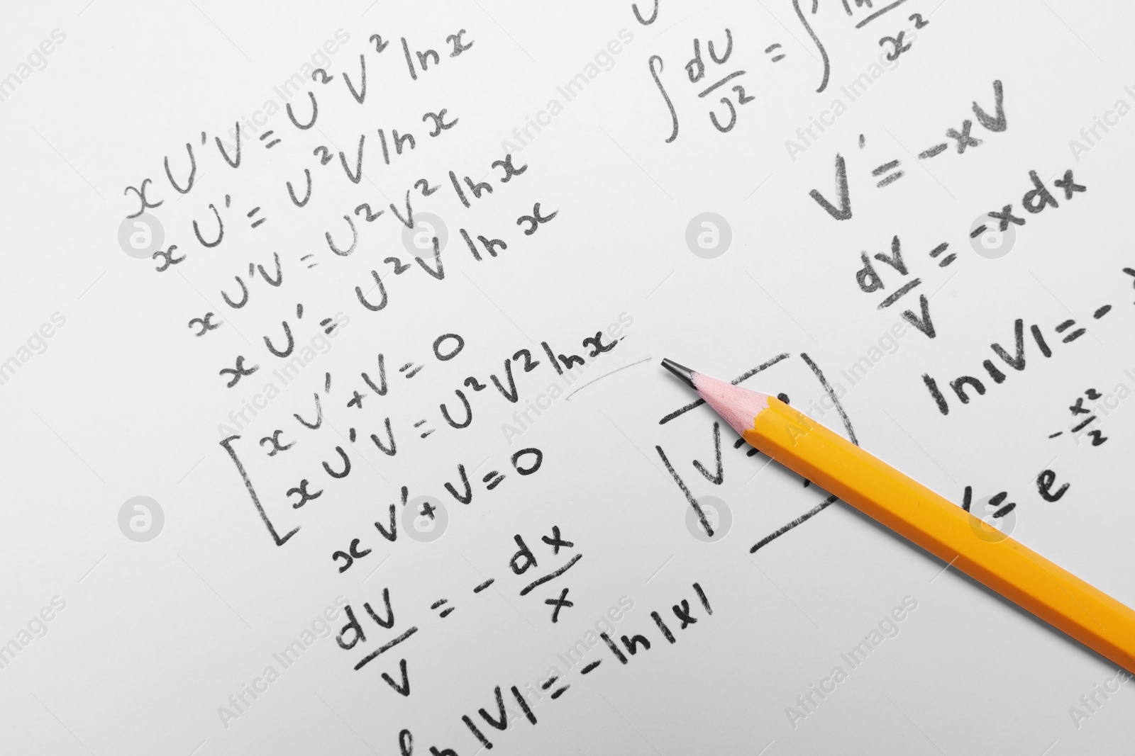 Photo of Sheet of paper with mathematical formulas and pencil, top view