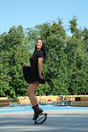 Photo of Beautiful woman doing exercises in kangoo jumping boots outdoors