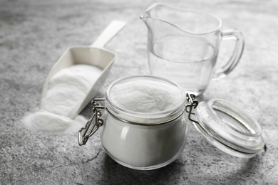 Photo of Baking soda in glass jar on grey table