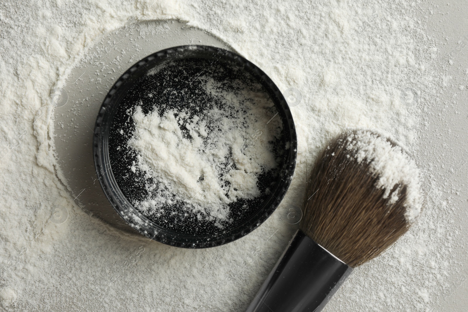 Photo of Rice loose face powder and makeup brush on light grey background, flat lay