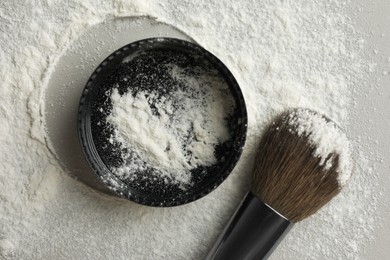 Rice loose face powder and makeup brush on light grey background, flat lay