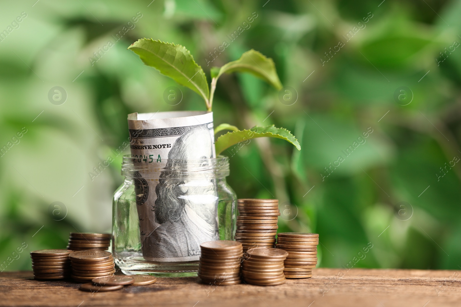 Photo of Money and sprout on wooden table against blurred background