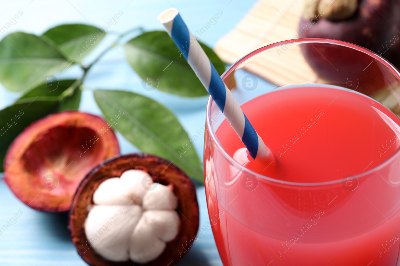 Photo of Delicious fresh mangosteen juice in glass, closeup. Space for text