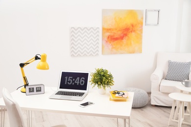 Stylish workplace with laptop on table in room