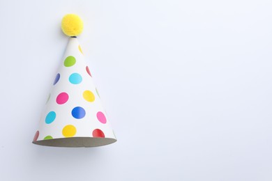Photo of One beautiful party hat on light background, top view. Space for text