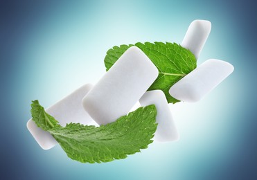 Image of Fresh mint leaves and chewing gum pads falling on light blue background