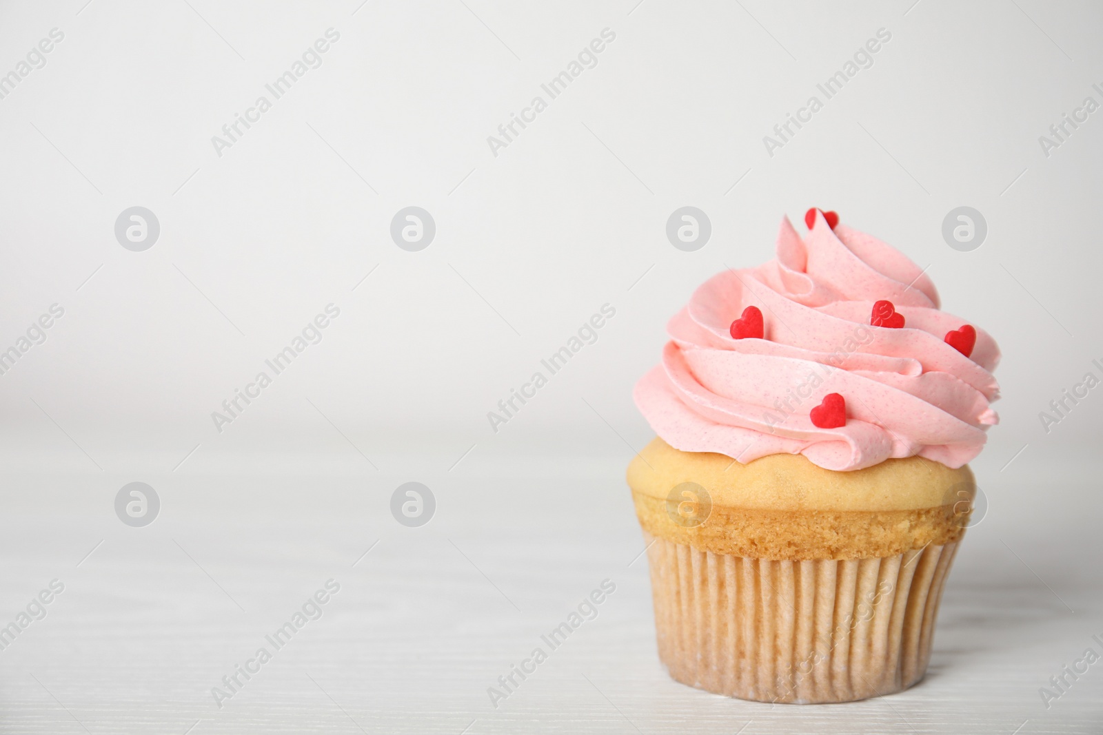 Photo of Tasty sweet cupcake on white table, space for text. Happy Valentine's Day
