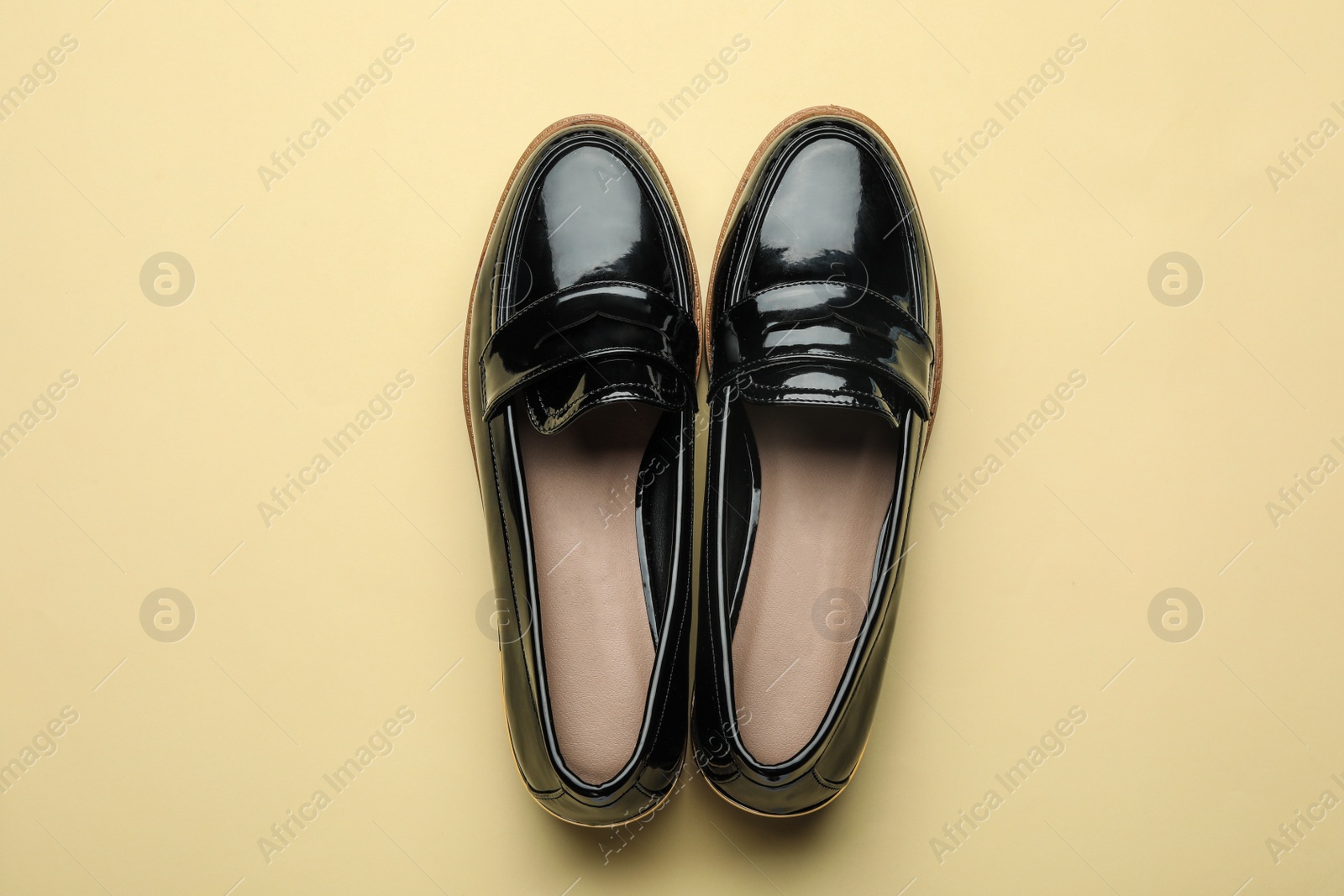 Photo of Pair of stylish female shoes on yellow background, top view