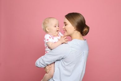 Portrait of happy mother with her baby on color background