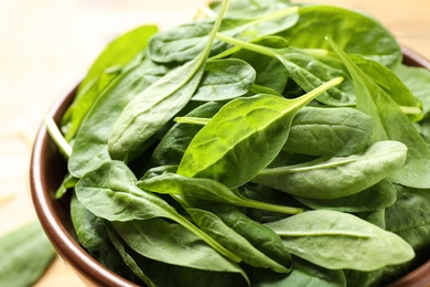 Photo of Fresh green healthy spinach in ceramic bowl, closeup