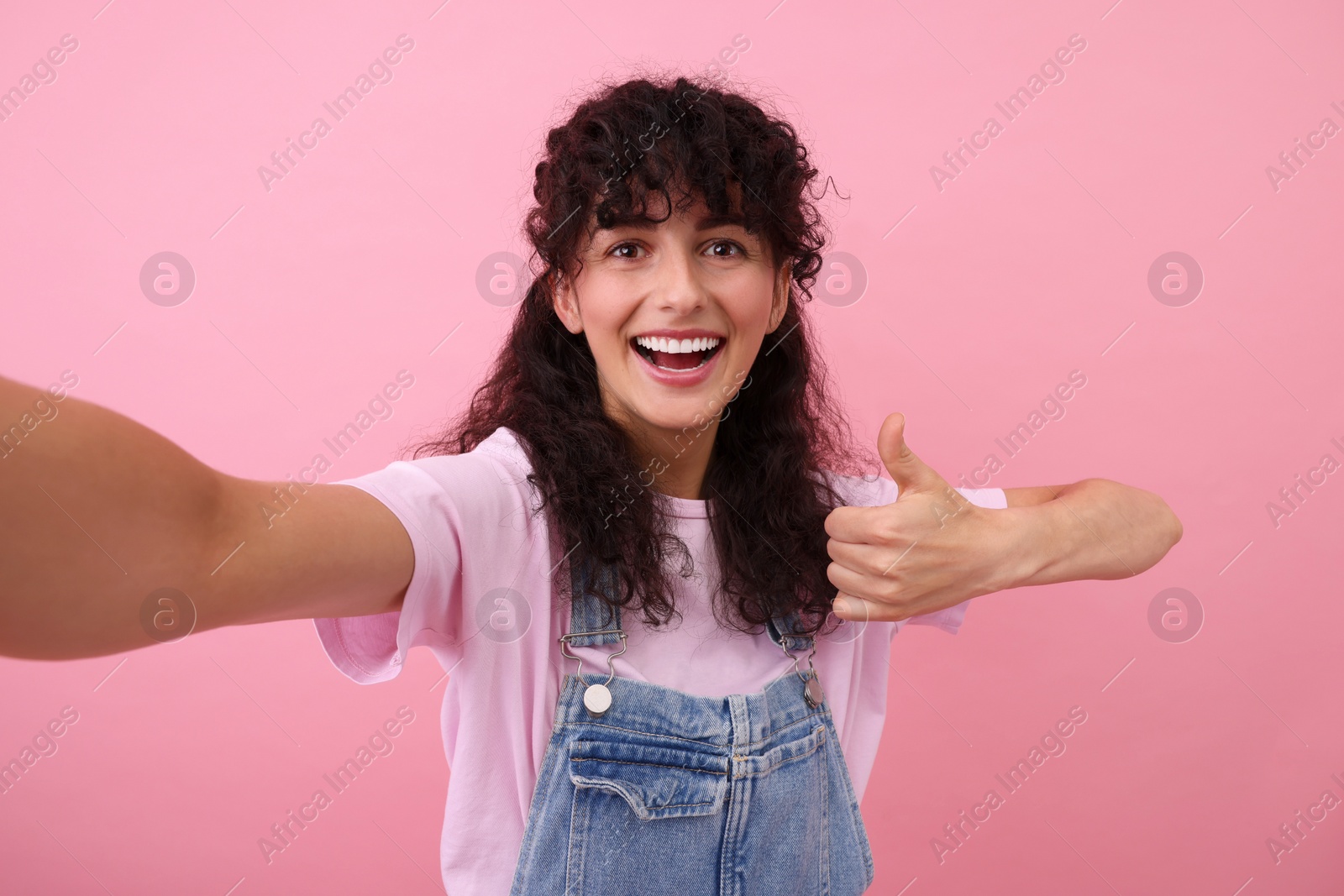 Photo of Beautiful woman taking selfie on pink background