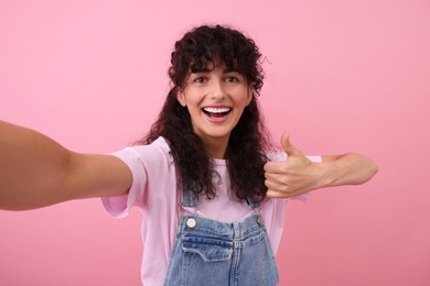 Photo of Beautiful woman taking selfie on pink background