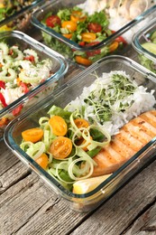 Photo of Healthy meal. Containers with different products on wooden table