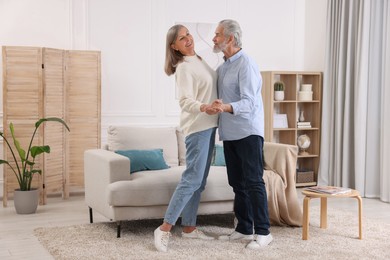 Photo of Happy affectionate senior couple dancing at home