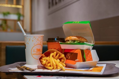 Photo of WARSAW, POLAND - SEPTEMBER 04, 2022: McDonald's French fries, burgers and drinks on table indoors
