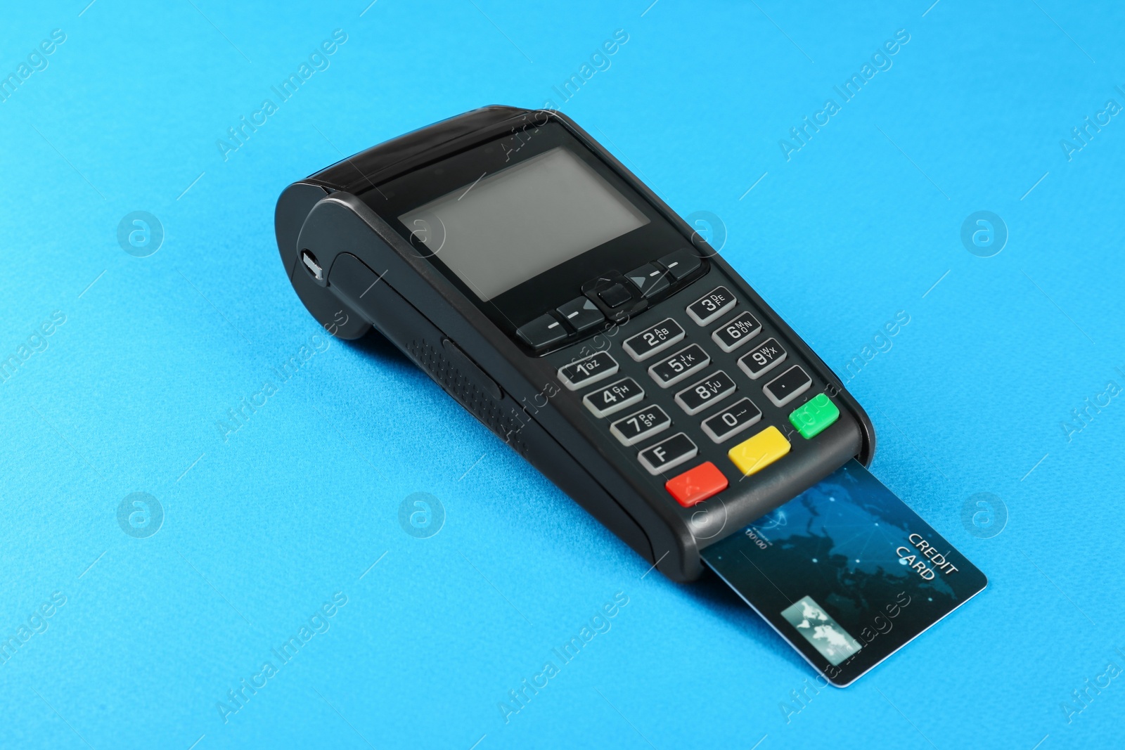 Photo of New modern payment terminal with credit card on light blue background