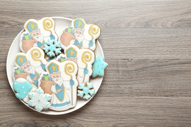 Tasty gingerbread cookies on wooden table, top view with space for text. St. Nicholas Day celebration