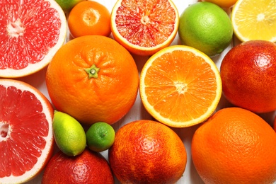 Photo of Many different citrus fruits as background, top view