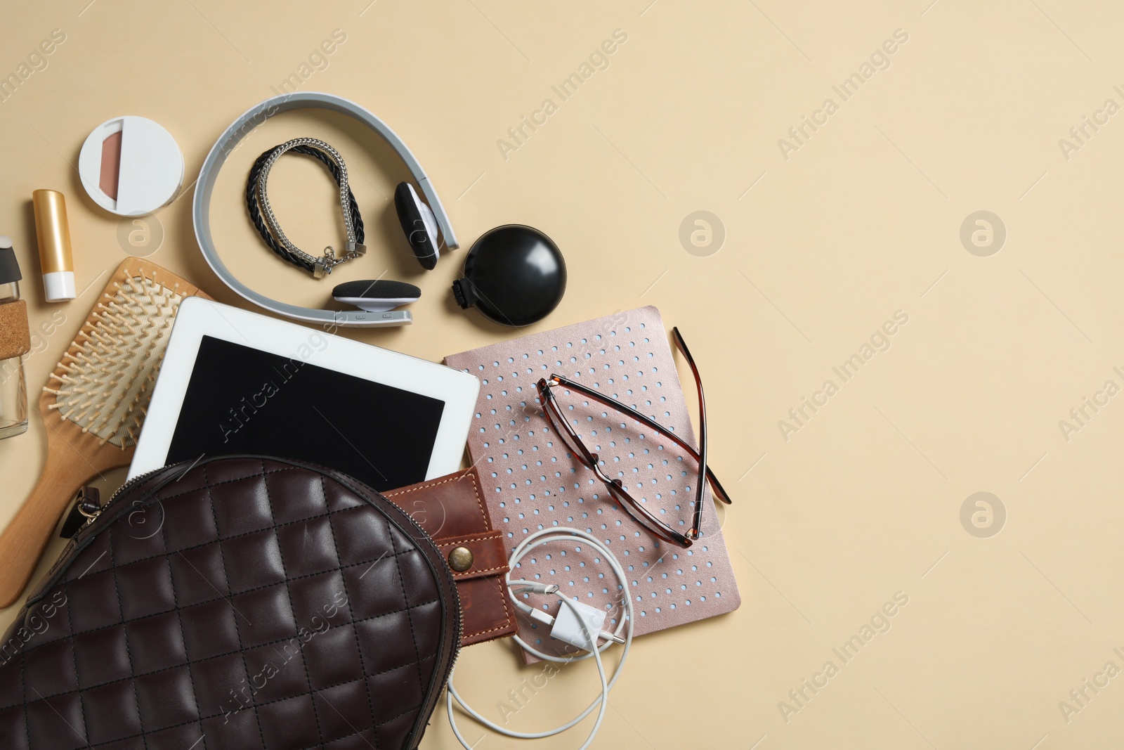Photo of Stylish urban backpack with different items on beige background, flat lay. Space for text