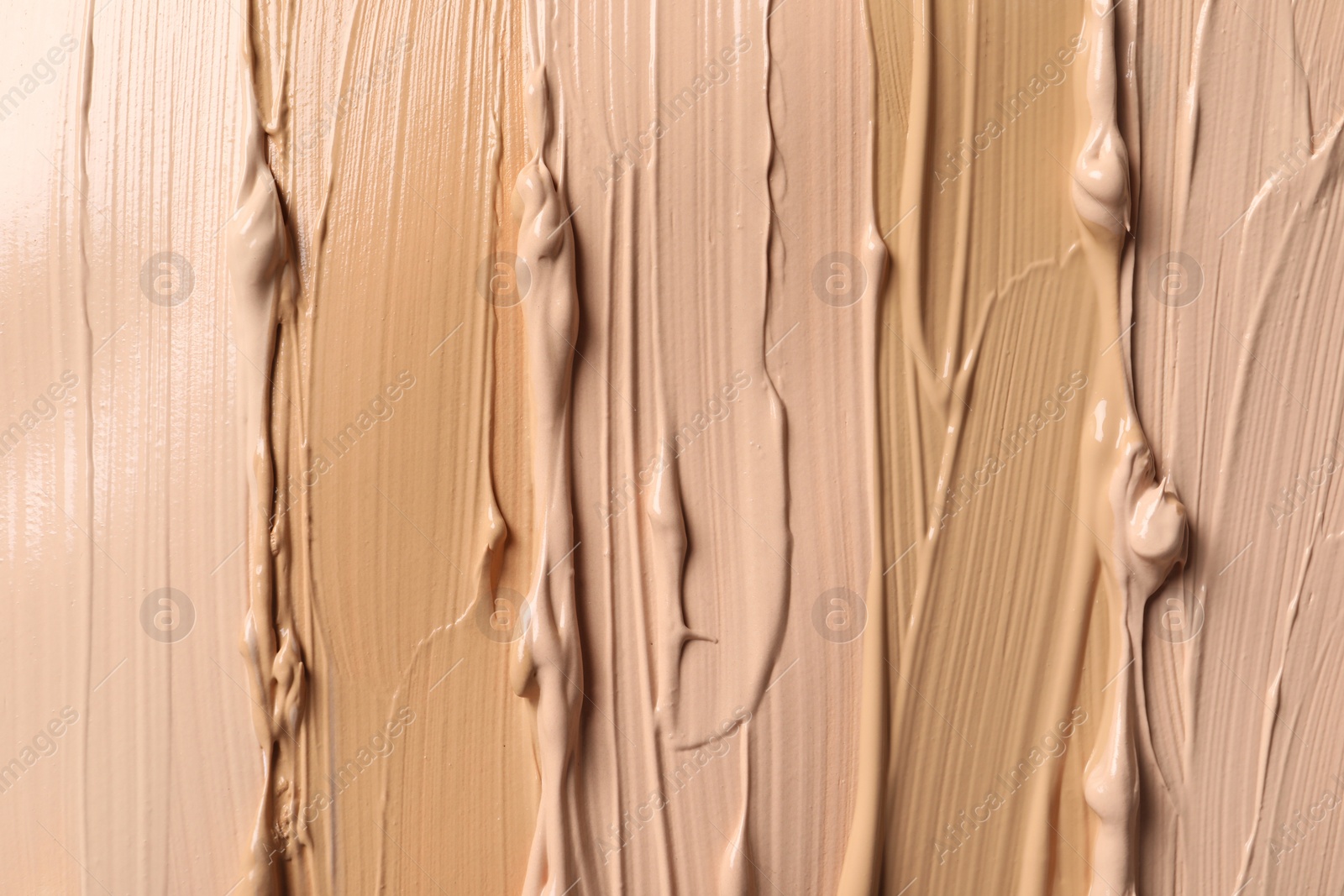 Photo of Samples of skin foundation as background, closeup