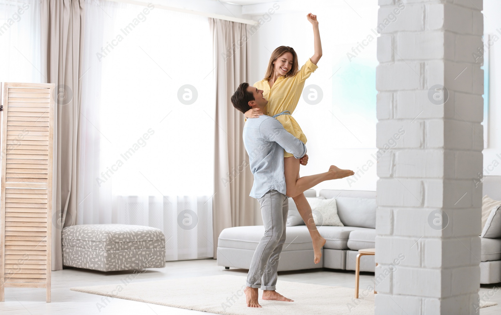 Photo of Beautiful young couple dancing in living at home