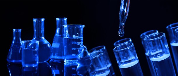 Image of Chemistry and chemical research. Collage of different laboratory glassware with liquids on black background, blue tone effect. Banner design