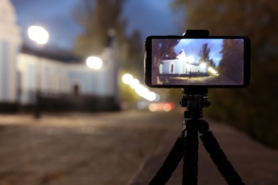 Taking photo with smartphone on tripod outdoors at night