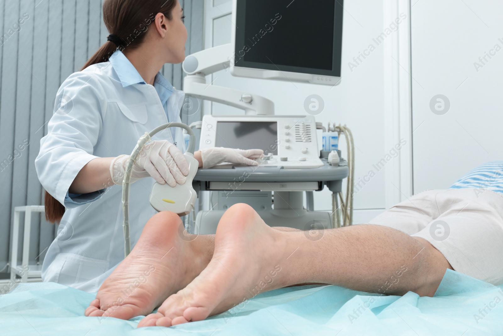 Photo of Doctor conducting ultrasound examination of patient's foot in clinic