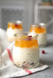 Photo of Creamy rice pudding with red currant and oatmeal in jar on table