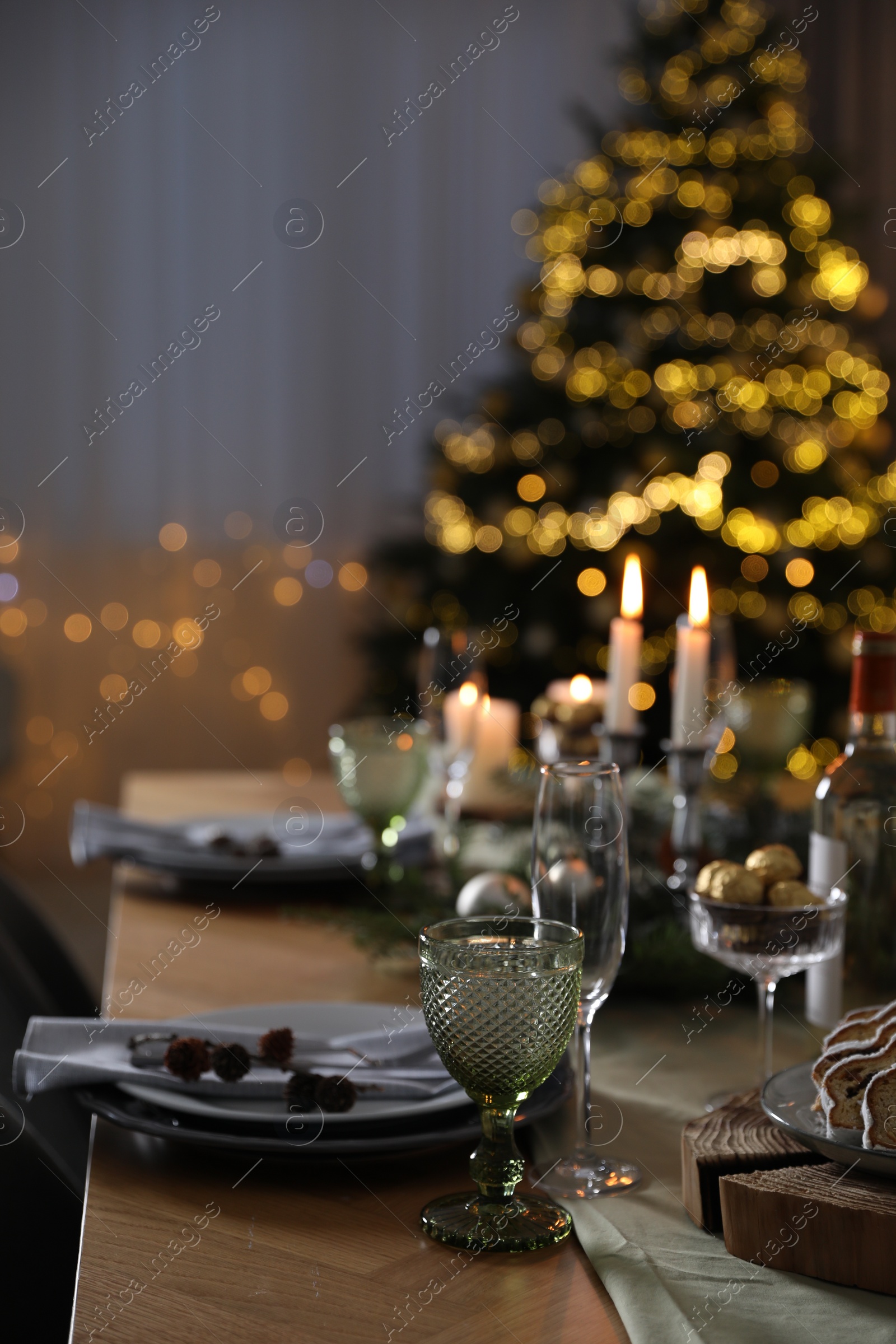 Photo of Christmas table setting with festive decor and dishware indoors