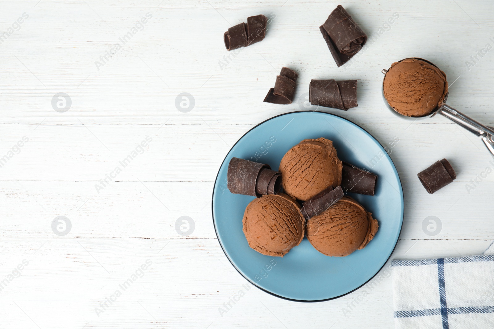 Photo of Flat lay composition with plate of ice cream, chocolate curls and scoop on white wooden table, space for text