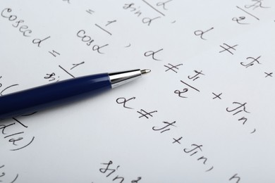 Photo of Sheet of paper with different mathematical formulas and pen, closeup