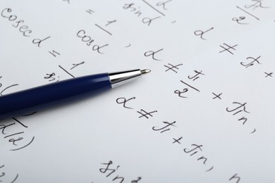 Sheet of paper with different mathematical formulas and pen, closeup