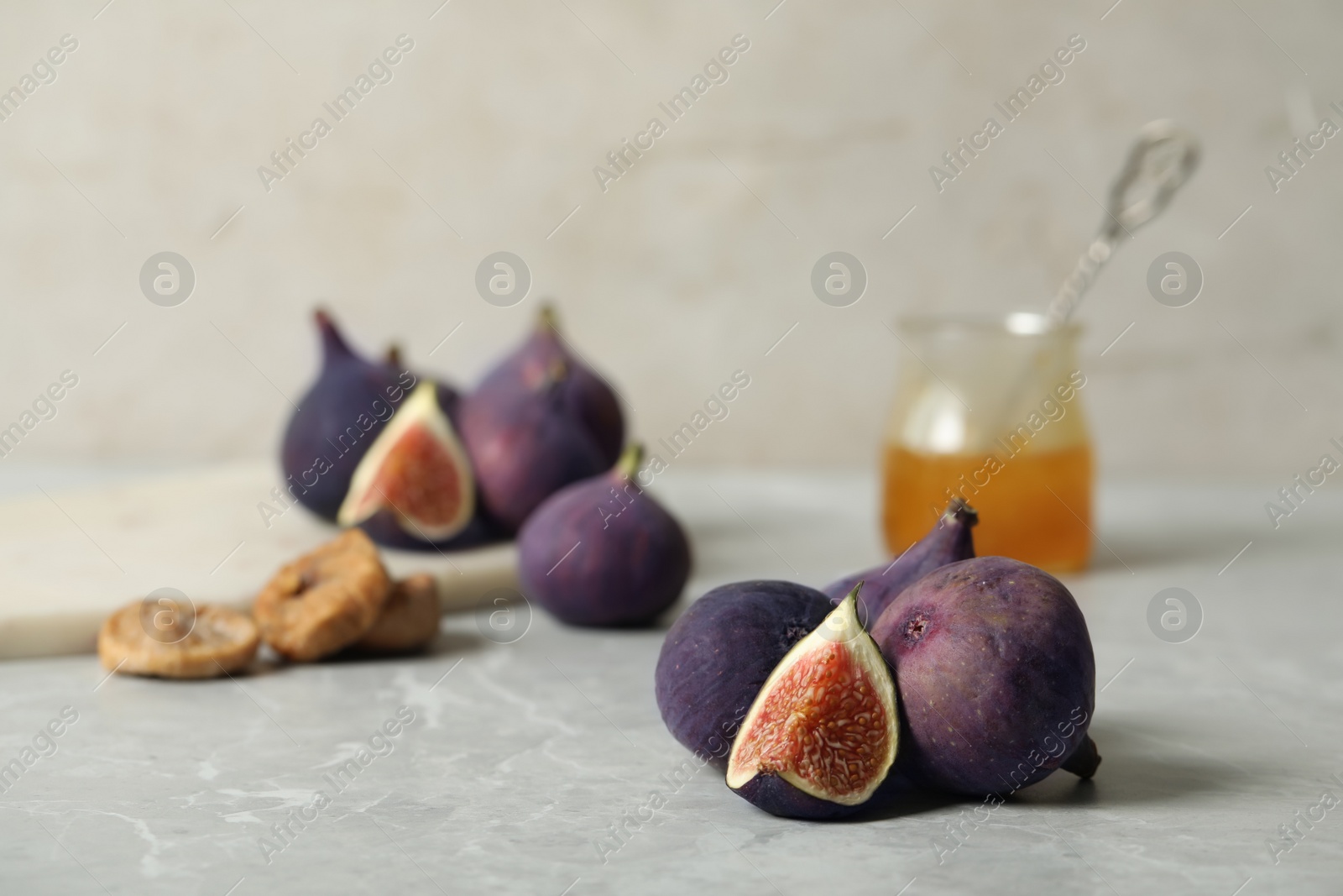 Photo of Tasty raw figs on light grey marble table. Space for text