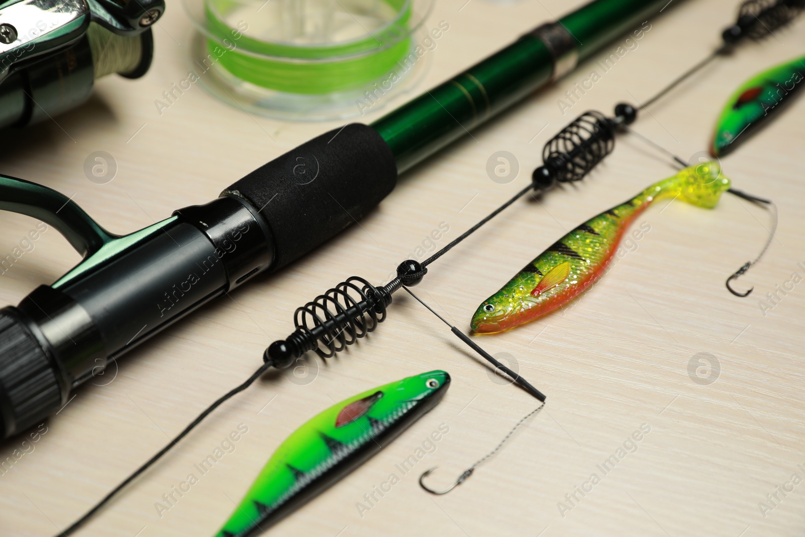 Photo of Fishing tackle on light wooden background, closeup