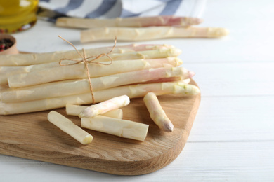 Photo of Fresh white asparagus on wooden table, closeup